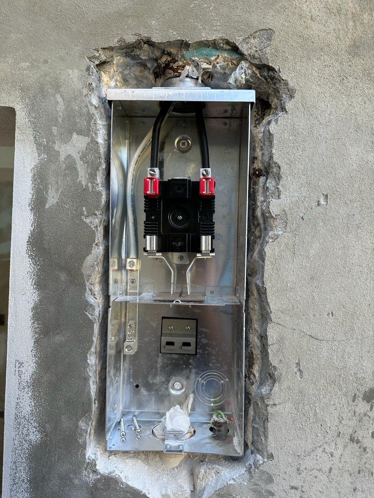 New meter socket set into a chased concrete wall, ready for the utility meter