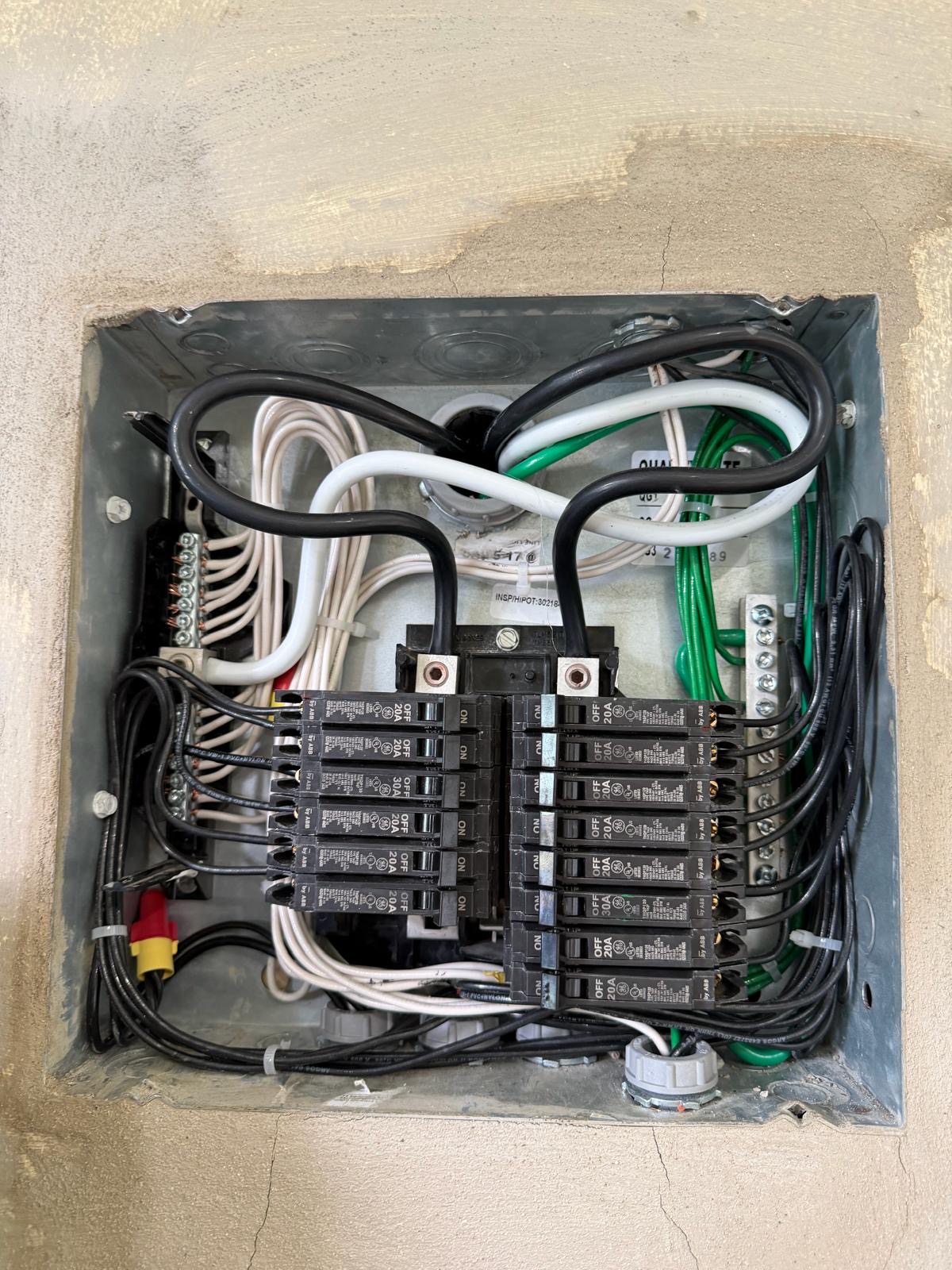 Open load center showing dressed branch-circuit wiring and labeled breakers