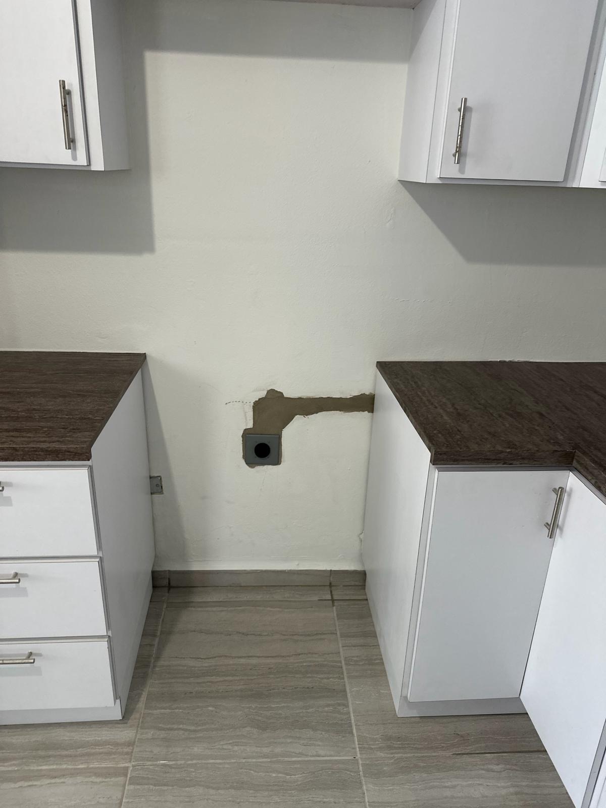Kitchen appliance circuit rough-in with the chase patched and device box set between cabinet runs